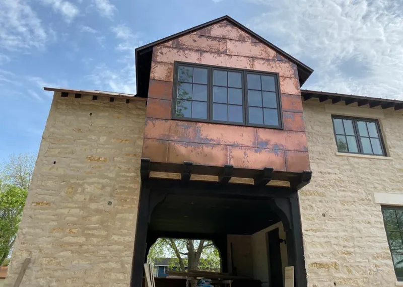 Copper metal panel facade on a stone building for Skylight Installation in Goldenrod